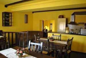 a dining room with yellow walls and tables and chairs at Pensiunea Michael's House in Rupea