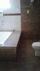 a bathroom with a toilet and a tub and a sink at Motel Premium (Adults Only) in Barbalha