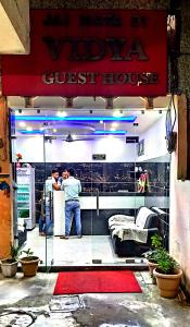 two men standing in front of a guest house at Vidya Guest House in Katra
