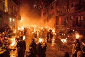 una multitud de personas de pie alrededor de incendios en una calle en Casa Espinalbet, en Castellar del Riu
