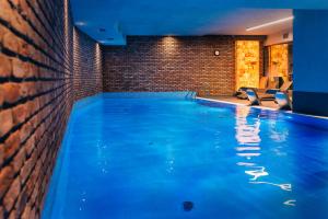 una gran piscina en una habitación con una pared de ladrillo en HOTEL ALMOND BUSINESS & SPA BY GRANO Gdańsk, en Gdansk