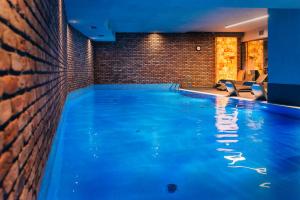 a large swimming pool in a room with a brick wall at GRANO HOTEL Gdańsk Riverside dawniej HOTEL ALMOND BUSINESS & SPA in Gdańsk