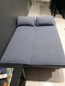 a bed with two pillows on it in a room at Budget Studio Apartment in Kuah