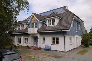 a house with a blue bench in front of it at Pension Grosser in Prerow