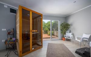 a room with a glass door with a table and chairs at Serene Summer Oasis - Pool, Jacuzzi, Sauna, Sea View - Lara in Drenje +59 photos