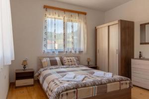 a bedroom with a bed with a dresser and a window at Villa Samodiva in Yagodina