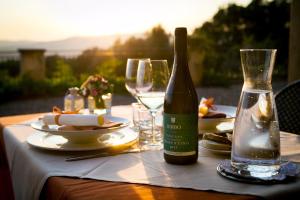 un tavolo con una bottiglia di vino e bicchieri di Tenuta il Sassone - Wine&Food a Massa Marittima