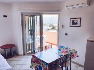 a table and chairs in a room with a balcony at Villa Dubravka in Lopar