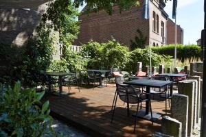 eine Gruppe von Tischen und Stühlen auf einer Terrasse in der Unterkunft Corbie Mol in Mol