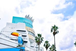 a building with a parrot sitting on a pole at Nagasaki Chapel Coconuts Hotel ＆Resort in Isahaya