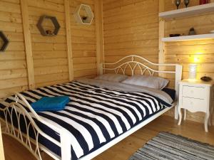 a bedroom with a bed in a log cabin at Piejūras namiņš in Kolka