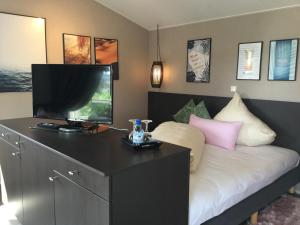 a bedroom with a bed with a flat screen tv at zu Jeddelohs Lodge Hotel in Gladenbach