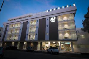 a large building with cars parked in front of it at M&F Hotel in Gallipoli