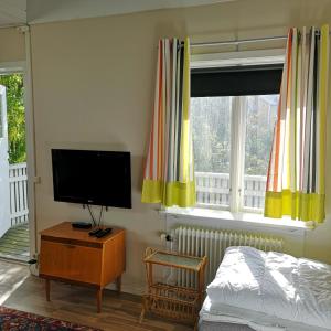 Schlafzimmer mit einem TV, einem Bett und einem Fenster in der Unterkunft Varbergs Vandrarhem in Varberg