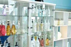 a glass cabinet filled with lots of bottles at Nagasaki Chapel Coconuts Hotel ＆Resort in Isahaya