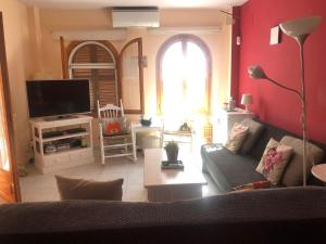 een woonkamer met een bank en een tv bij Torre Almadrava in Denia