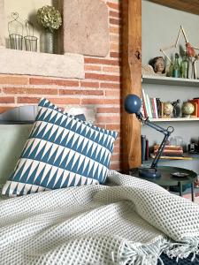 Dormitorio con cama con almohada y lámpara en Au Sigala, en Lisle-sur-Tarn