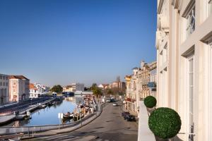 uma vista para um canal com edifícios e pessoas num barco em Hotel Aveiro Palace em Aveiro