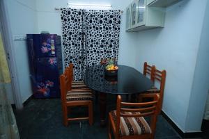 a dining room with a black table and chairs at LA CASA THE HOMESTAY in Trivandrum +10 photos