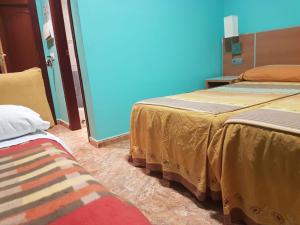 a room with two beds and a blue wall at Camping-Hotel Los Molinos in Ruidera