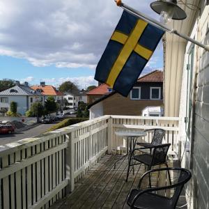 eine Flagge auf einem Balkon mit einem Tisch und Stühlen in der Unterkunft Varbergs Vandrarhem in Varberg