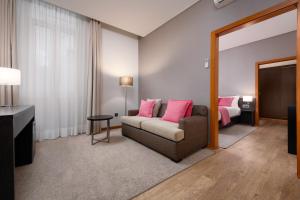 sala de estar con sofá y cama en Hotel Aveiro Palace, en Aveiro