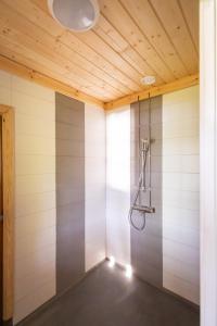 a shower in a room with a wooden ceiling at Villa Vahtivuori in Rantasalmi