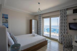 a bedroom with a bed and a view of the ocean at Fener Hotel Café & Kahvalti in Cesme