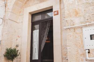 a window of a building with a black door at Dimora Alborelli in Alberobello