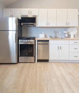uma cozinha com electrodomésticos de aço inoxidável e armários brancos em A Wave Inn - Montauk em Montauk