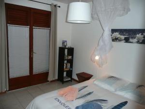 - une chambre avec un lit, une lampe et une fenêtre dans l'établissement BUNGALOW DU VOYAGEUR, au Marin