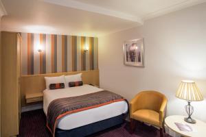 a hotel room with a bed and a chair at Mercure Doncaster Centre Danum Hotel in Doncaster
