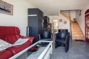 - un salon avec un canapé rouge et deux chaises dans l'établissement Villa Océane, à Groix