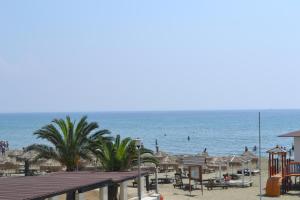- une plage avec des chaises et des parasols et l'océan dans l'établissement 13 Sandy Beach Mackenzie, à Larnaka