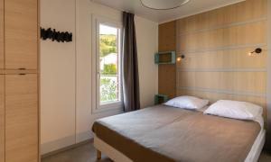 Saint-Martin-dʼArrossaDomaine Chalets Larlapean的带床和窗户的卧室