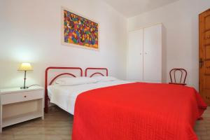 1 dormitorio con 1 cama con manta roja en Villino Melina, en Santa Maria al Bagno