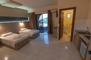 a hotel room with two beds and a bathroom at Rose Hotel Faliraki in Faliraki +23 photos