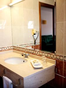 a bathroom with a sink and a large mirror at Hotel Castro in Santiago de Compostela