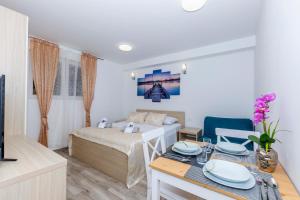 a bedroom with a bed and a table with plates on it at Apartments West Coast in Split