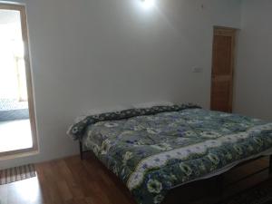 A bed or beds in a room at Chosdup Guest House