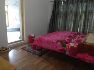 A bed or beds in a room at Chosdup Guest House