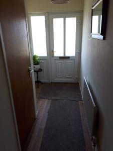 a hallway with a door with two windows and a rug at 3 MacNean Park in Belcoo