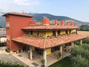 ein großes rotes Gebäude mit einem Balkon auf dem Dach in der Unterkunft B&B Casa Zuane in Rivoli Veronese