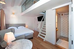 a small bedroom with a bed and a staircase at Casa Colloredo Free Parking in Rovinj