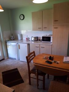 a kitchen with a wooden table and a table and a dining room at 3 MacNean Park in Belcoo