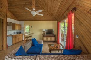 a living room with a couch and a ceiling fan at Wikkid Resort in Dixon Cove