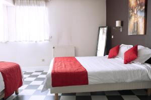 um quarto com uma cama com um cobertor vermelho e branco em Cit'Hotel Europeen em Angoulême