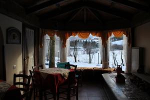 a dining room with a table and a large window at Rifugio Del Pettirosso in Pescasseroli