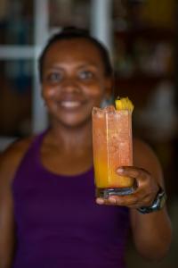 een vrouw houdt een drankje in haar hand bij Wikkid Resort in Dixon Cove