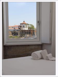 a window with two towels and a view of a building at Stay In Apartments - D. Hugo 23 in Porto